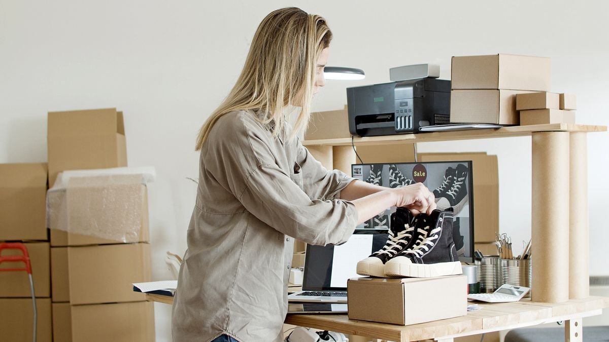 Woman packing sneakers into a box to ship to a buyer