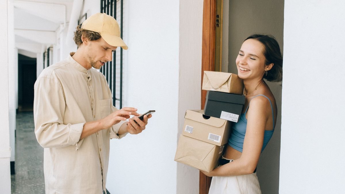 Smiling woman receiving a food delivery at her door