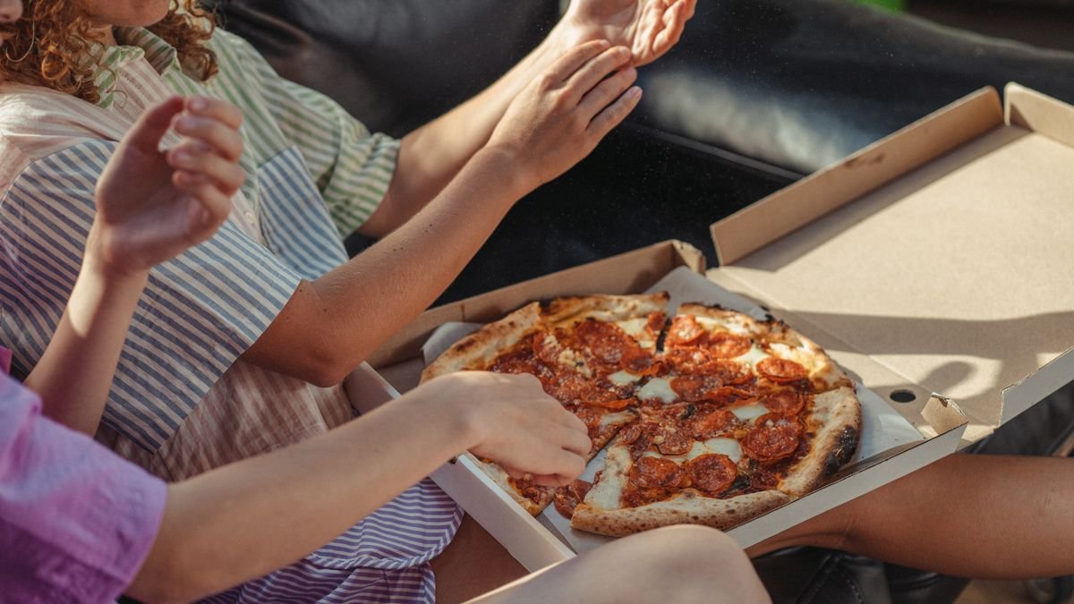 Friends sharing a takeout pizza at home